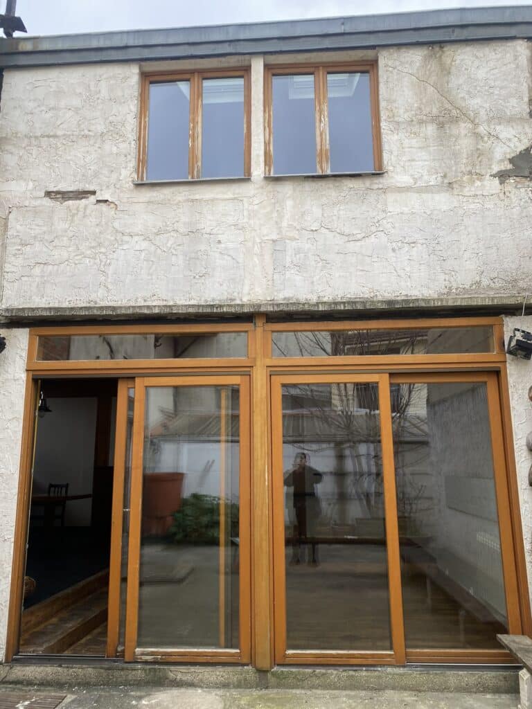 facade avec fenetre bois en bonne état avec façade abimé